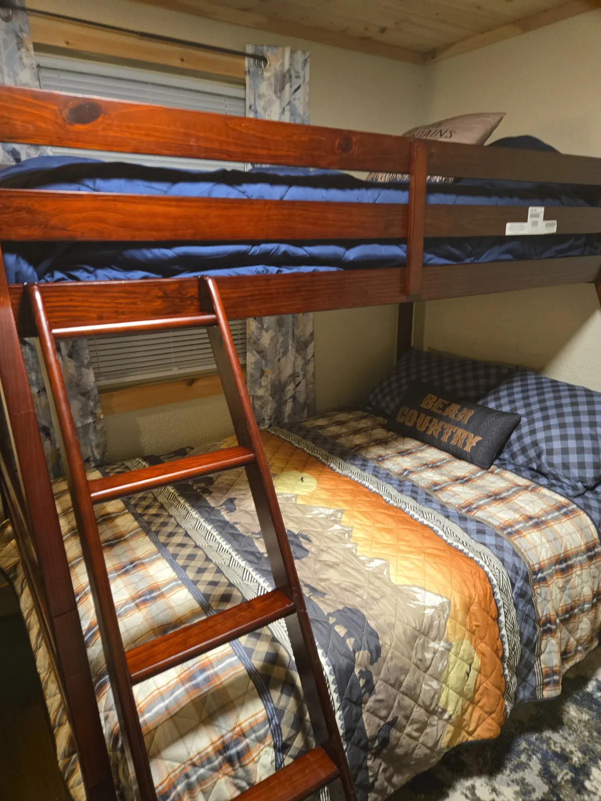 The photo shows a set of bunk beds with colorful bedding and a sturdy ladder, creating a playful and welcoming atmosphere. The bedding and arrangement suggest a space ideal for kids, friends, or families to bond and unwind.