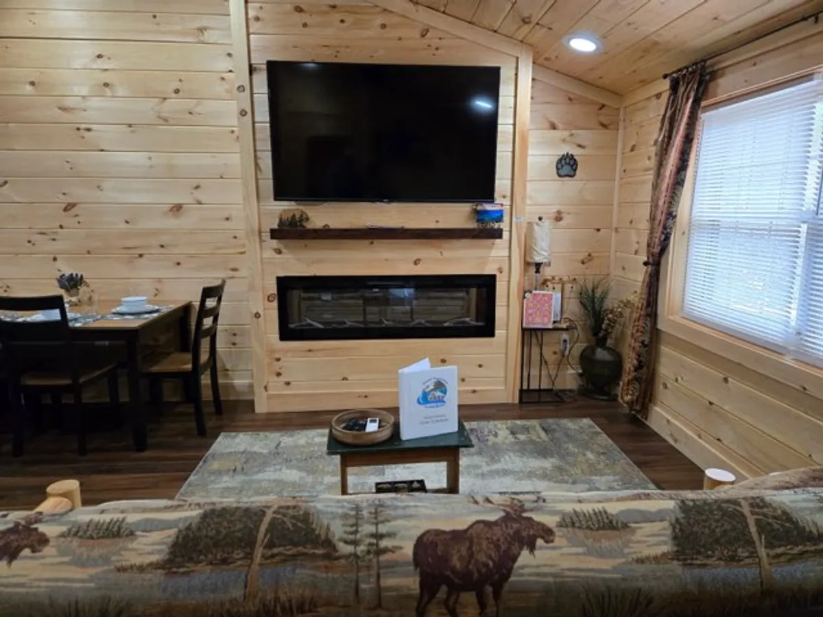 An open-concept space displaying a fireplace, TV, dining table, and a comfortable sofa. The area blends relaxation with entertainment, perfect for family gatherings, movie nights, and intimate dinners.